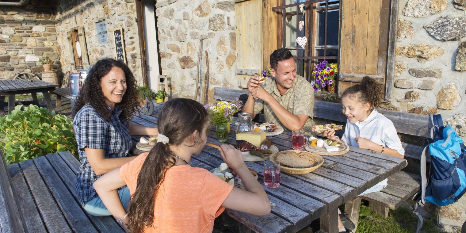 Familienessen vor einer Almhütte am Nassfeld in der Nähe des Almhotel Kärnten