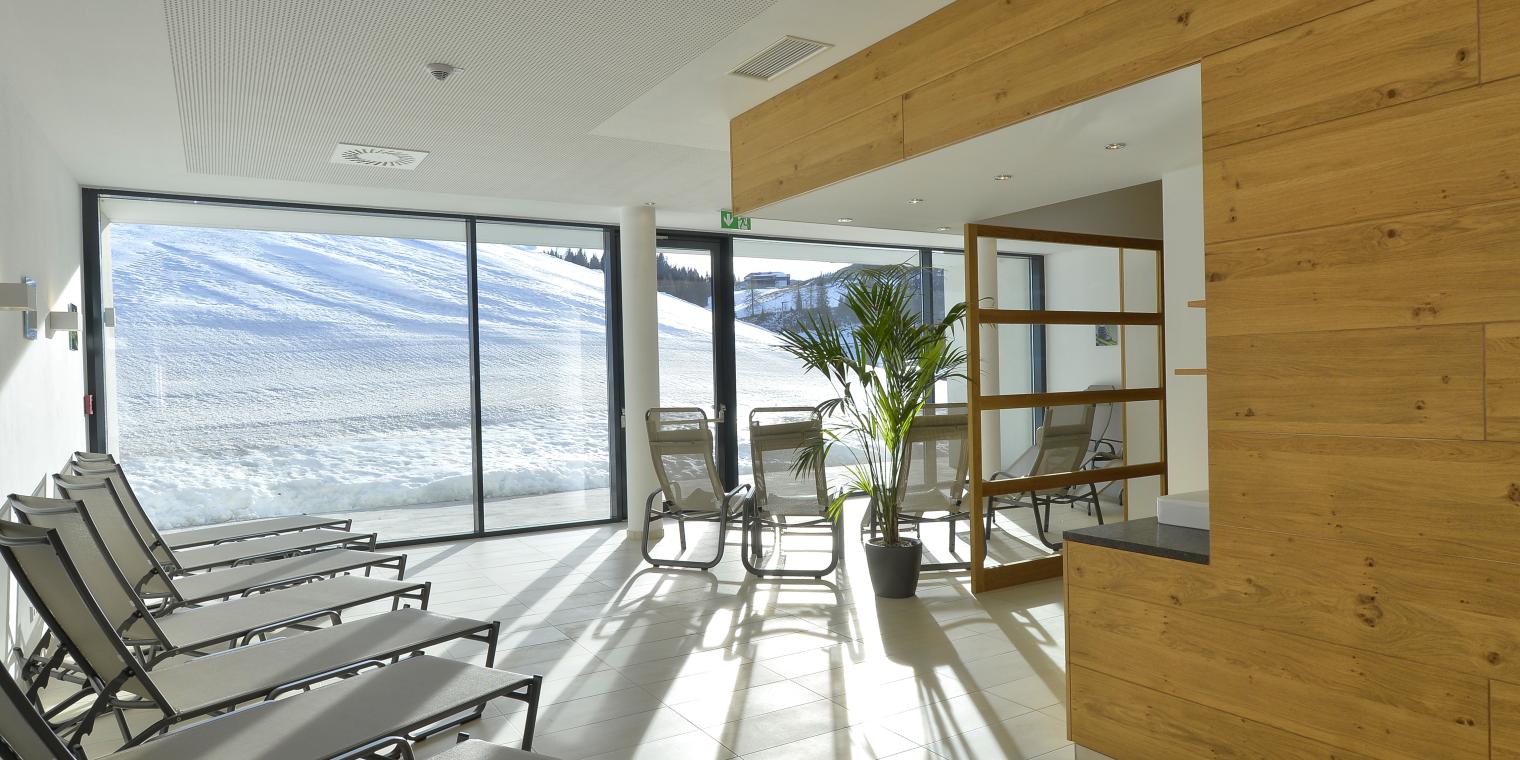 Ruheraum der Saunawelt mit Panoramablick auf die Piste im Almhotel Kärnten am Nassfeld
