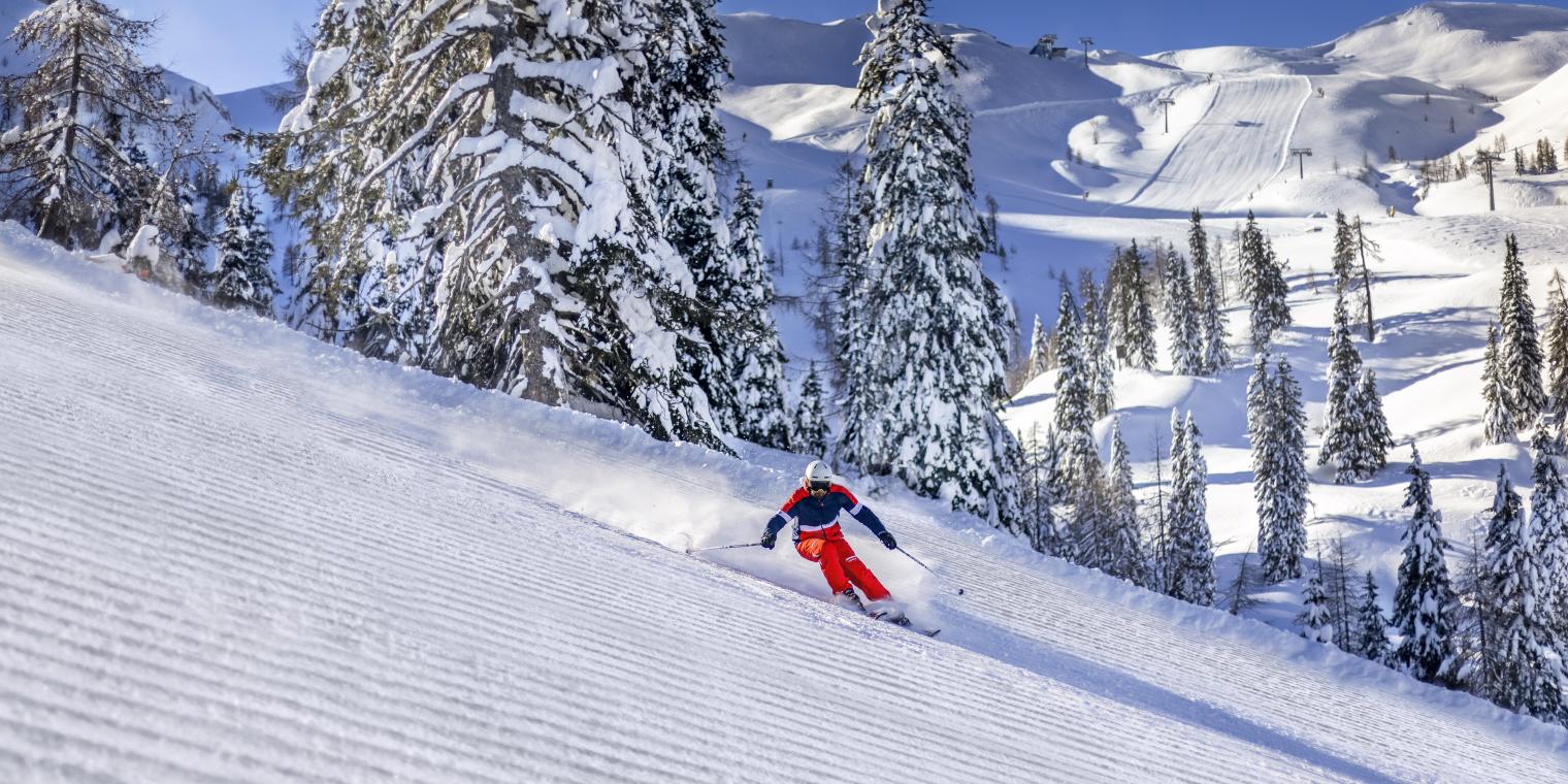 Skifahrer auf frisch präparierter Piste am Nassfeld in Kärnten, in der Nähe des Almhotel Kärnten