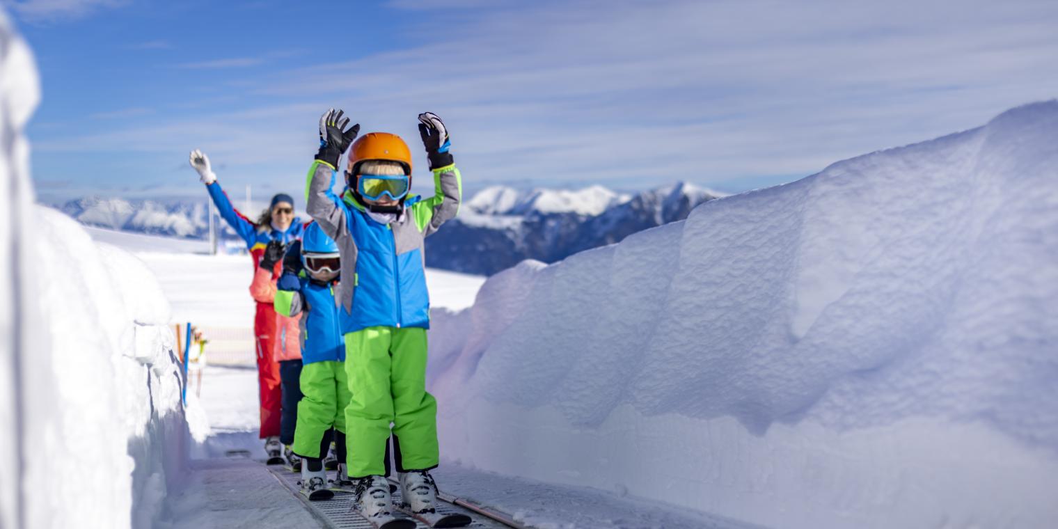 Skikinder auf Förderband am Nassfeld in Kärnten in der Nähe des Almhotel Kärnten