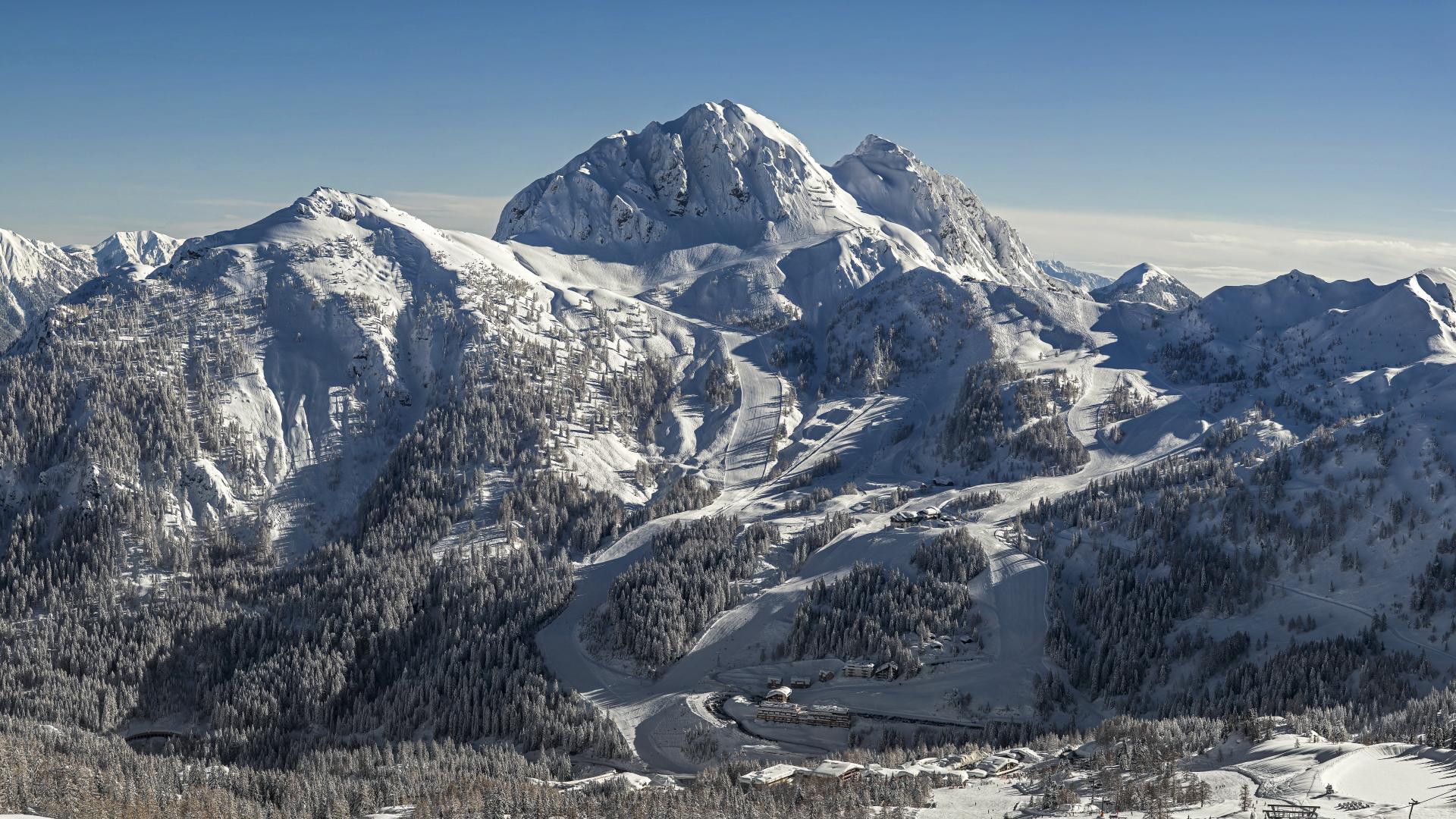 Majestätische überragt der schneebedeckte Gartnerkofel, an dessen Fuß sich das Almhotel Kärnten befindet, das Nassfeld
