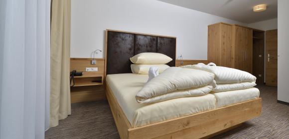 Komfortables Doppelzimmer mit Holzm&ouml;beln im Almhotel K&auml;rnten am Nassfeld