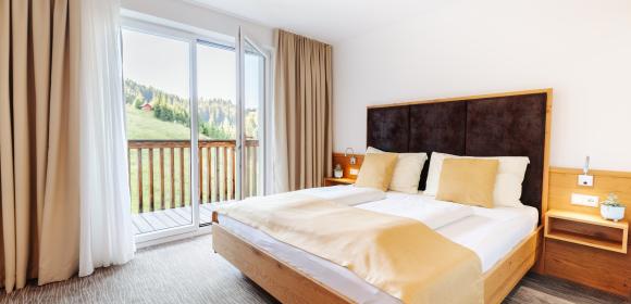 Modernes Doppelzimmer mit Balkonblick im Almhotel K&auml;rnten am Nassfeld