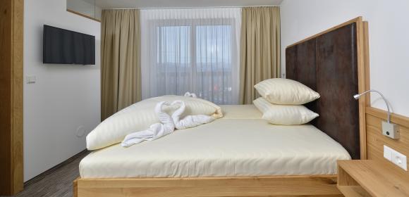 Gem&uuml;tliches Doppelzimmer mit Holzbett im Almhotel K&auml;rnten am Nassfeld