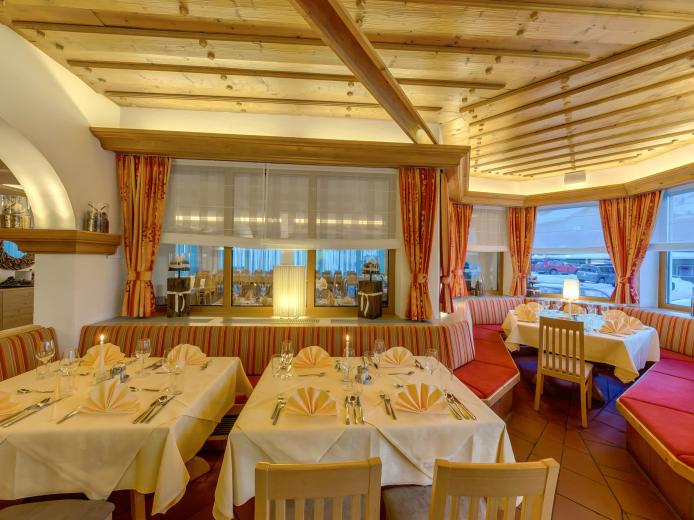 Das stilvoll eingerichtete Restaurant im Almhotel Kärnten bietet warme Holzelemente, große Fenster mit beeindruckender Aussicht und gemütliche Sitzbereiche. Die einladend gedeckten Tische schaffen eine einladende Atmosphäre für Genießer regionaler Spezialitäten in behaglichem Alpenambiente. Das gemütliches Restaurant mit Panoramablick im Almhotel Kärnten am Nassfeld