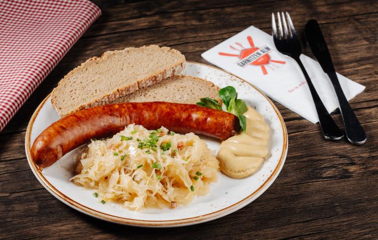 Gailtaler Hauswürstel mit Sauerkraut serviert in der Garnitzenalm nahe dem Almhotel Kärnten am Nassfeld