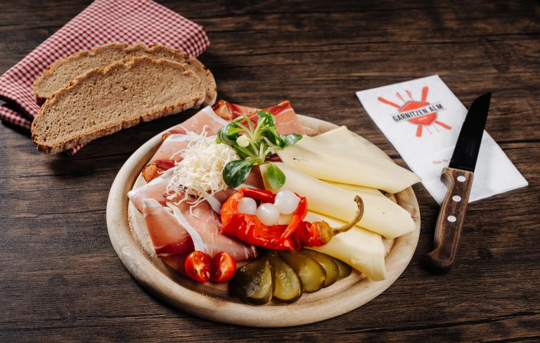 Kärntner Jausenbrett mit Bauernbrot serviert in der Garnitzenalm nahe dem Almhotel Kärnten am Nassfeld