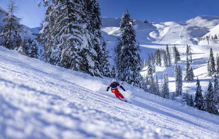 Skifahrer auf verschneiter Piste am Nassfeld in Kärnten in der Nähe des Almhotel Kärnten