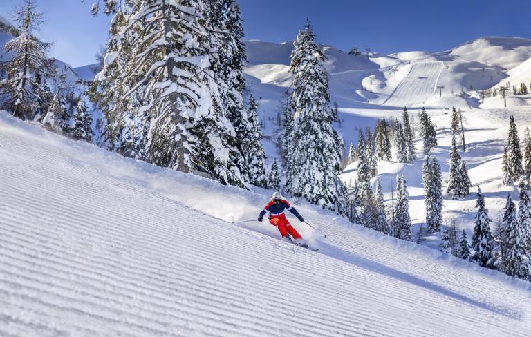 Skifahrer auf frisch präparierter Piste am Nassfeld in Kärnten, in der Nähe des Almhotel Kärnten