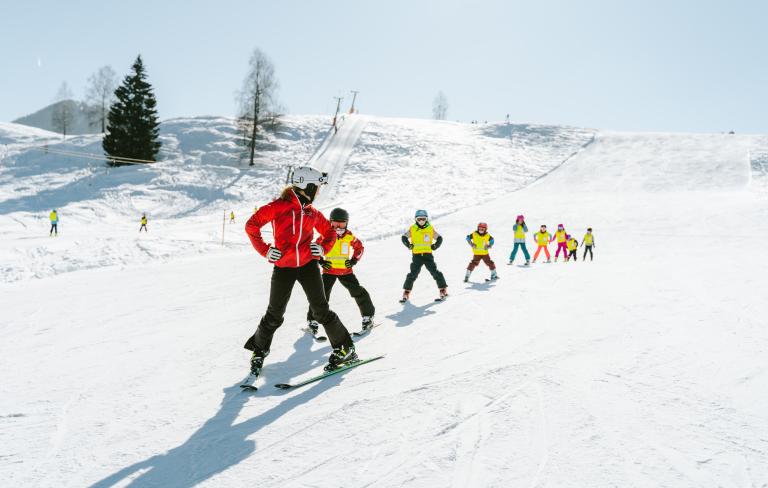 Skikurs mit Kinder im Sonnenschein am Nassfeld, in der Nähe des Almhotel Kärnten