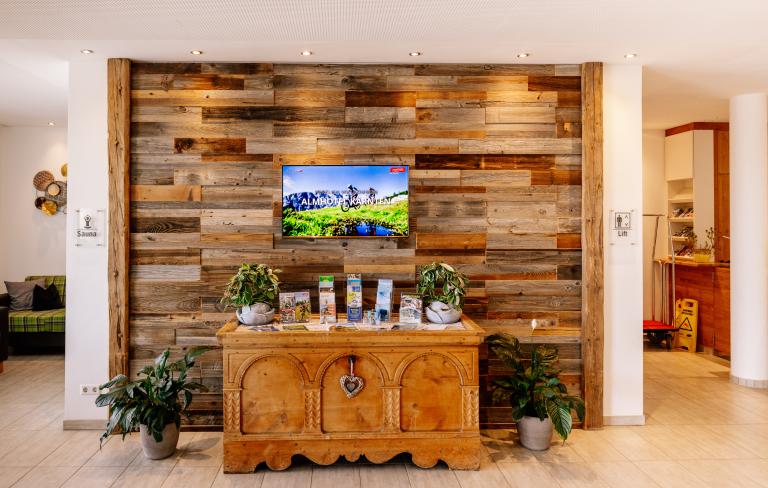 Gemütliche Hotellobby mit Holzwand im Almhotel Kärnten am Nassfeld
