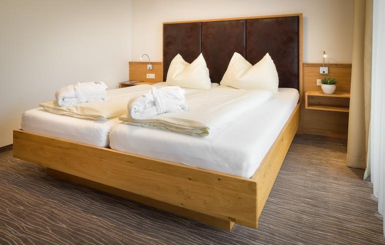 Komfortables Doppelzimmer mit Holzbett im Almhotel Kärnten am Nassfeld