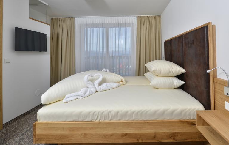 Gemütliches Doppelzimmer mit Holzbett im Almhotel Kärnten am Nassfeld